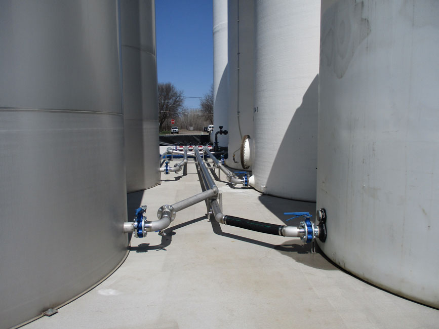 Photo shows pluming running from the main valves on bulk liquid fertilizer tanks. 