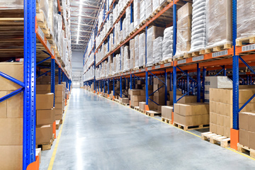 Row of shelves full of boxes in a warehouse.