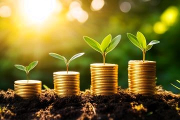 stacks of coins on dirt with plants sprouting from coins