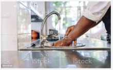 Individual washing hands in kitchen sink